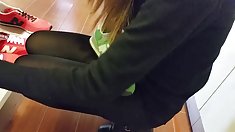 cô gái sexy cửa hàng trong quần màu đen sáng bóng